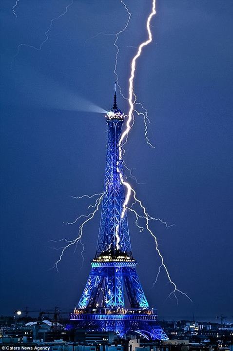 lightning illuminating the night sky behind the Eiffel Tower